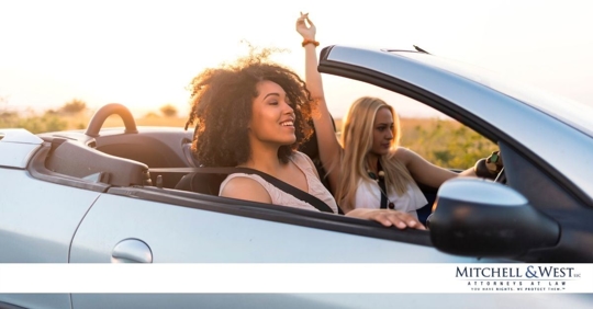 two young women running driving in a convertible