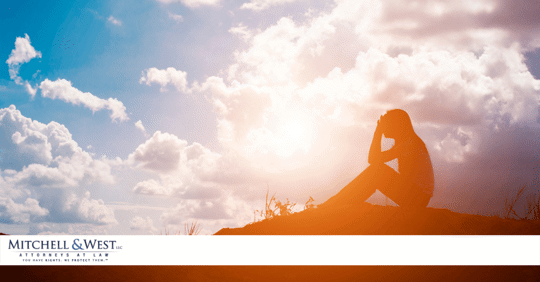 silhouette of woman sitting on hill in the clouds
