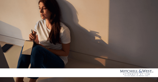 woman sad sitting on floor with a notebook