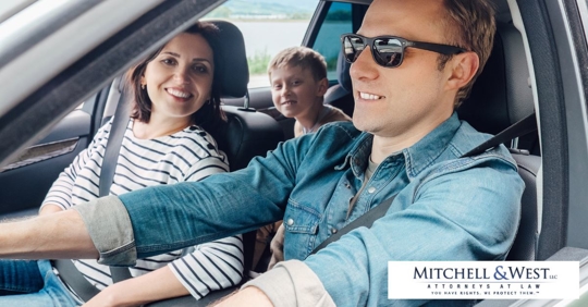 man driving car with wife and son as passengers